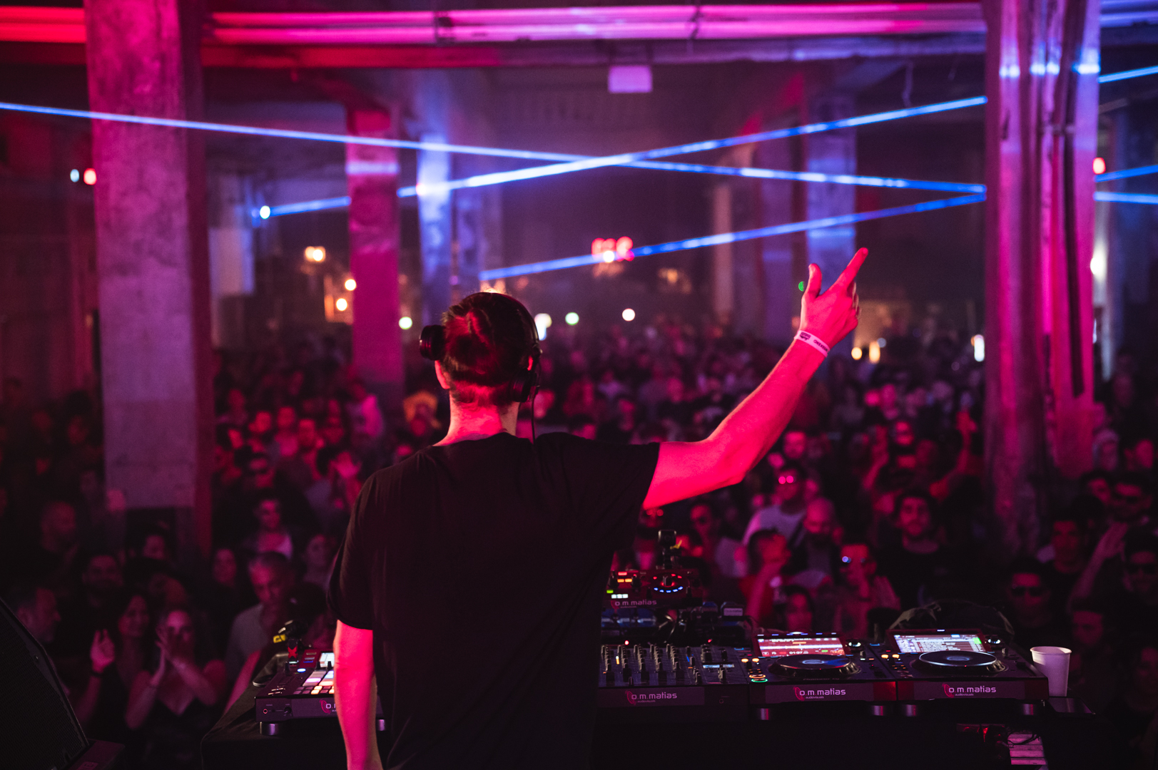 DJ behind decks with pink lights